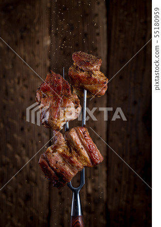 Carving fork with pieces of steak on rustic background 55180959