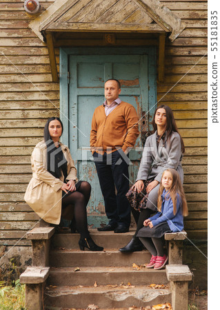 Family portrait in the forest backgroung of old house. Mother father and two daughter. Happy family 55181835