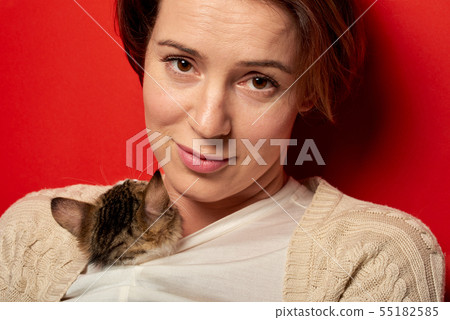 Woman playing with a little cat Woman playing with a little cat 55182585