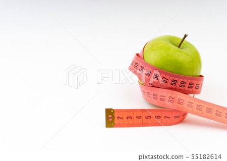 Green apple with red measuring tape. Selective Green apple with red measuring tape. Selective 55182614
