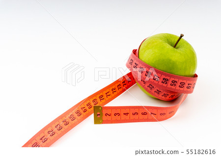 Green apple with red measuring tape. Selective Green apple with red measuring tape. Selective 55182616