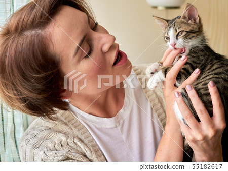 Beautiful mature woman playing with a little cat Beautiful mature woman playing with a little cat 55182617