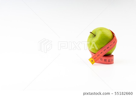 Green apple with red measuring tape. Selective 55182660