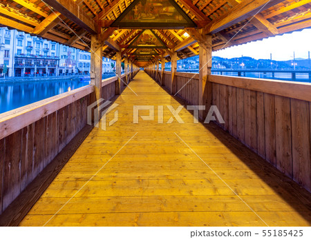 Lucerne. The famous Chapel, Kapellbrucke bridge at dawn in night lighting. Lucerne. The famous Chapel, Kapellbrucke bridge at dawn in night lighting. 55185425