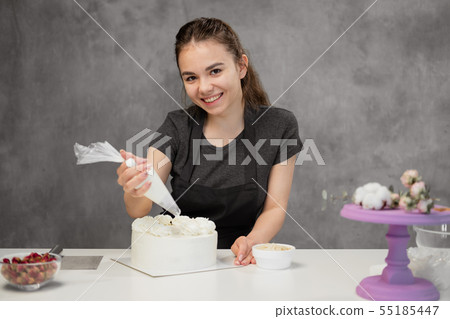 Confectioner at work. Cream cake decorating. Cook table preparing a cake. Confectioner at work. Cream cake decorating. Cook table preparing a cake. 55185447