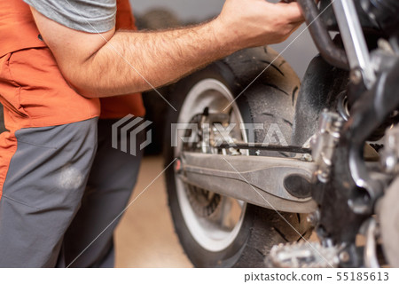 mechanic close up repairing motorbike in repair garage. mechanic close up repairing motorbike in repair garage. 55185613