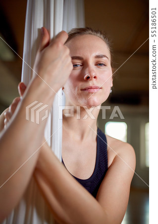 Instructor in aerial yoga portrait close-up. Hipster girl with an expressive look yoga trainer 55186501