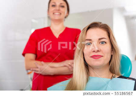 Portrait of a dentist discussing a treatment plan with a patient on a tablet Portrait of a dentist discussing a treatment plan with a patient on a tablet 55186567