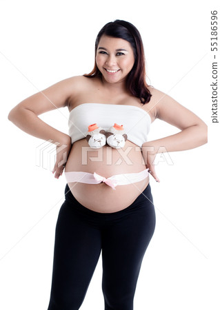 Pregnant woman's belly with baby shoes and ribbon bow Pregnant woman's belly with baby shoes and ribbon bow 55186596