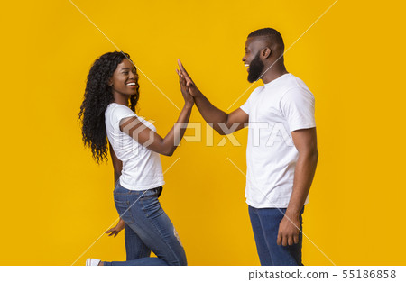 Happy man and woman greeting each other with high five 55186858