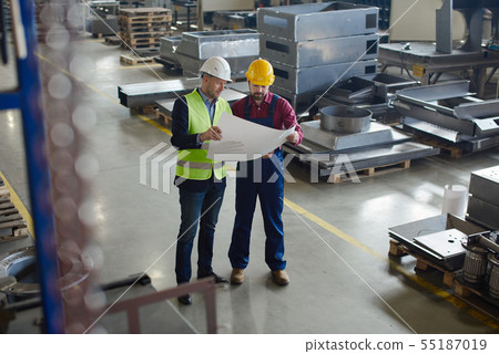 Engineers in hard hats working at the industrial plant. 55187019