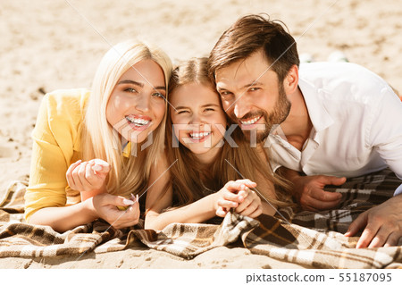 Happy parents and daughter lying together on picnic blanket Happy parents and daughter lying together on picnic blanket 55187095