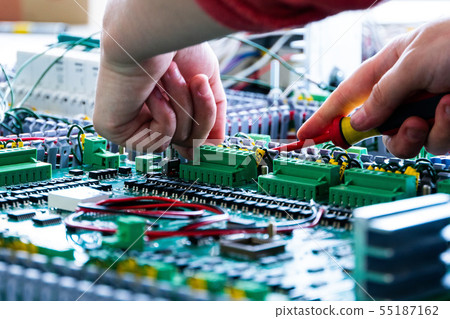 close up of electrician working with cables and wires on the assembly line, the installation of the 55187162