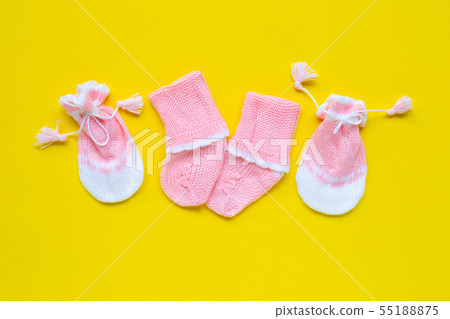 Baby gloves and socks on yellow background. Baby gloves and socks on yellow background. 55188875