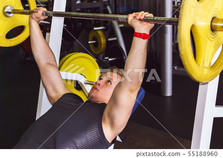 young man performs barbell bench press young man performs barbell bench press 55188960
