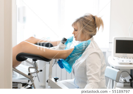 A gynecologist examines a patient on a 55189797