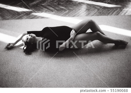 Pregnant moman lies near the big window. Model dressed in black bodysuit. She put her hand on the 55190088