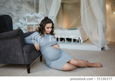 Pregnant woman sit near the armchair. Beautiful woman waiting for a baby. Elegant pregnant model at Pregnant woman sit near the armchair. Beautiful woman waiting for a baby. Elegant pregnant model at 55190377