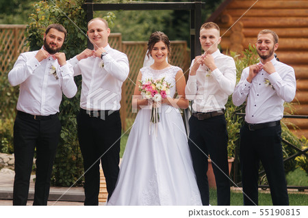 Charming bride stand by the groomsman on the backyard Charming bride stand by the groomsman on the backyard 55190815