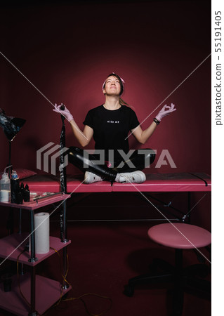 Portrait of a professional tattoo master woman. Black clothes, and dreadlocks. Red, pink and white Portrait of a professional tattoo master woman. Black clothes, and dreadlocks. Red, pink and white 55191405