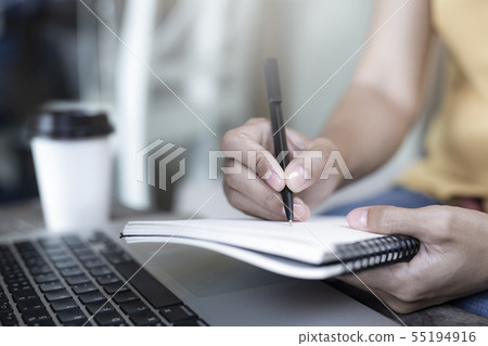Women holding a pen writing a notebook. 55194916