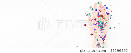 Woman hand with festive color star confetti 55196362