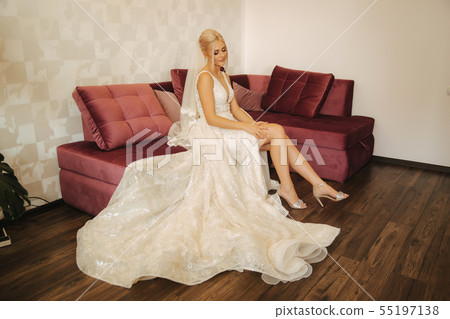 Young and beautiful bride at home. Blond hair girl in wedding dress Young and beautiful bride at home. Blond hair girl in wedding dress 55197138