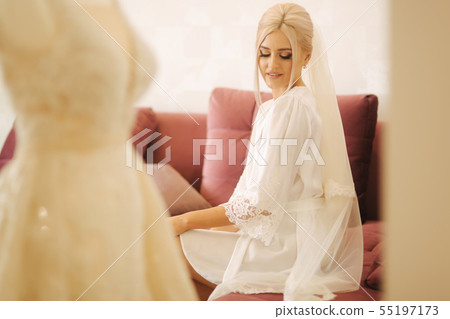 Morning of beautiful blond hair bride near the wedding dress Morning of beautiful blond hair bride near the wedding dress 55197173