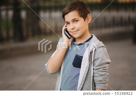 Young boy call his mom. Teenage boy use phone outside Young boy call his mom. Teenage boy use phone outside 55198922