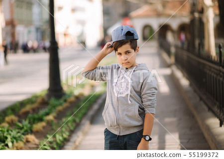 Portrait of little boy in cap. Stylish boy walking in the city 55199372