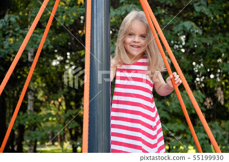 Little beautiful girl playing on the carousel in the park on the playground. 55199930