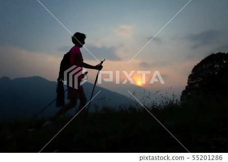 Girl during a sunset evening trek in the hills 55201286