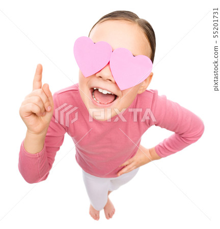 Little girl is holding hearts over her eyes Little girl is holding hearts over her eyes 55201731