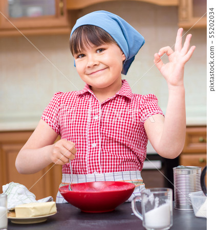 Girl is cooking in kitchen Girl is cooking in kitchen 55202034