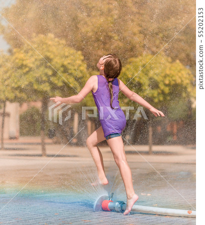 Girl is enjoying fountain with cold water Girl is enjoying fountain with cold water 55202153