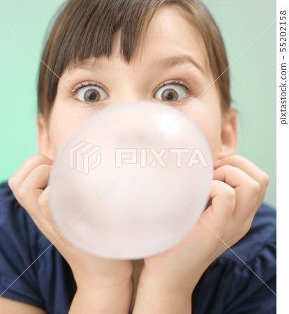Little girl is blowing big bubble gum Little girl is blowing big bubble gum 55202158