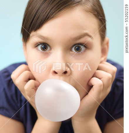 Little girl is blowing big bubble gum Little girl is blowing big bubble gum 55202159