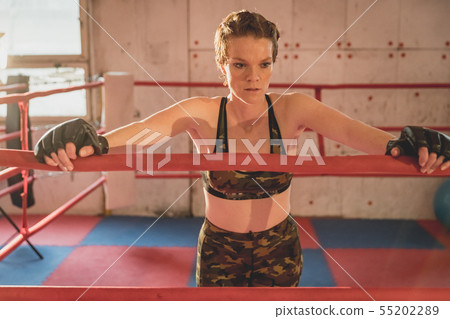 Young woman prepares for matches MMA in the cage. 55202289