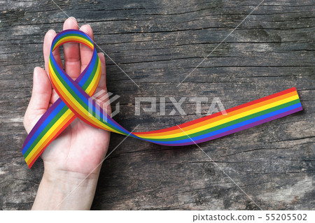 LGBT Rainbow ribbon awareness on human hand 55205502