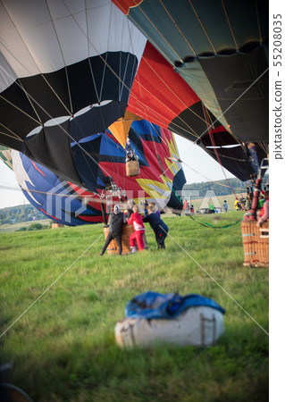 People holding the traveling balloon that's ready to take off 55208035