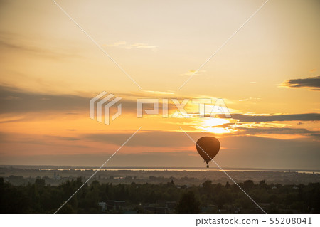An orange air balloon flying over the forest on a background of bright sunset - countryside An orange air balloon flying over the forest on a background of bright sunset - countryside 55208041