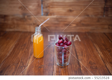 Sweet cherry, black cherries in a glass on wooden background with fresh juicy in glass bottle 55213528