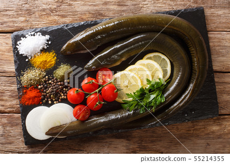 Raw eel with spices, vegetables and lemon close-up Raw eel with spices, vegetables and lemon close-up 55214355