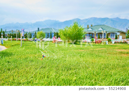 Green field with sprinkler. Green field with sprinkler. 55214908