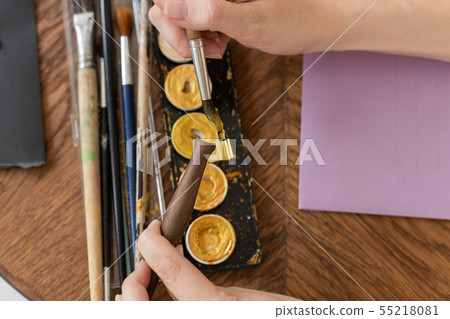 The artist is preparing to work. Applies paint to the brush. Close-up. The atmosphere of the The artist is preparing to work. Applies paint to the brush. Close-up. The atmosphere of the 55218081