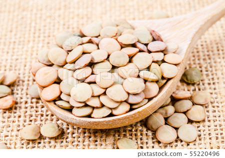 Close up brown lentil seeds on wooden spoon. 55220496