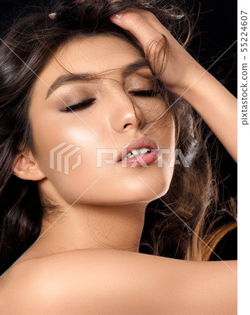 Portrait of young beautiful woman over dark background Portrait of young beautiful woman over dark background 55224607