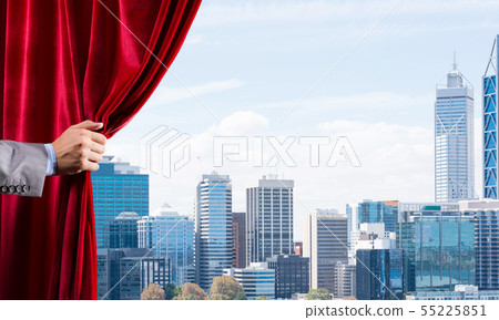 Modern business cityscape behind curtain opened by businessman hand 55225851