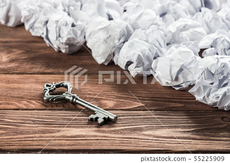 Concept of success and opportunity with old key among paperballs 55225909