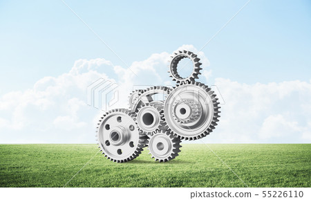 Abstract mechanism with cogwheels on green meadow Abstract mechanism with cogwheels on green meadow 55226110